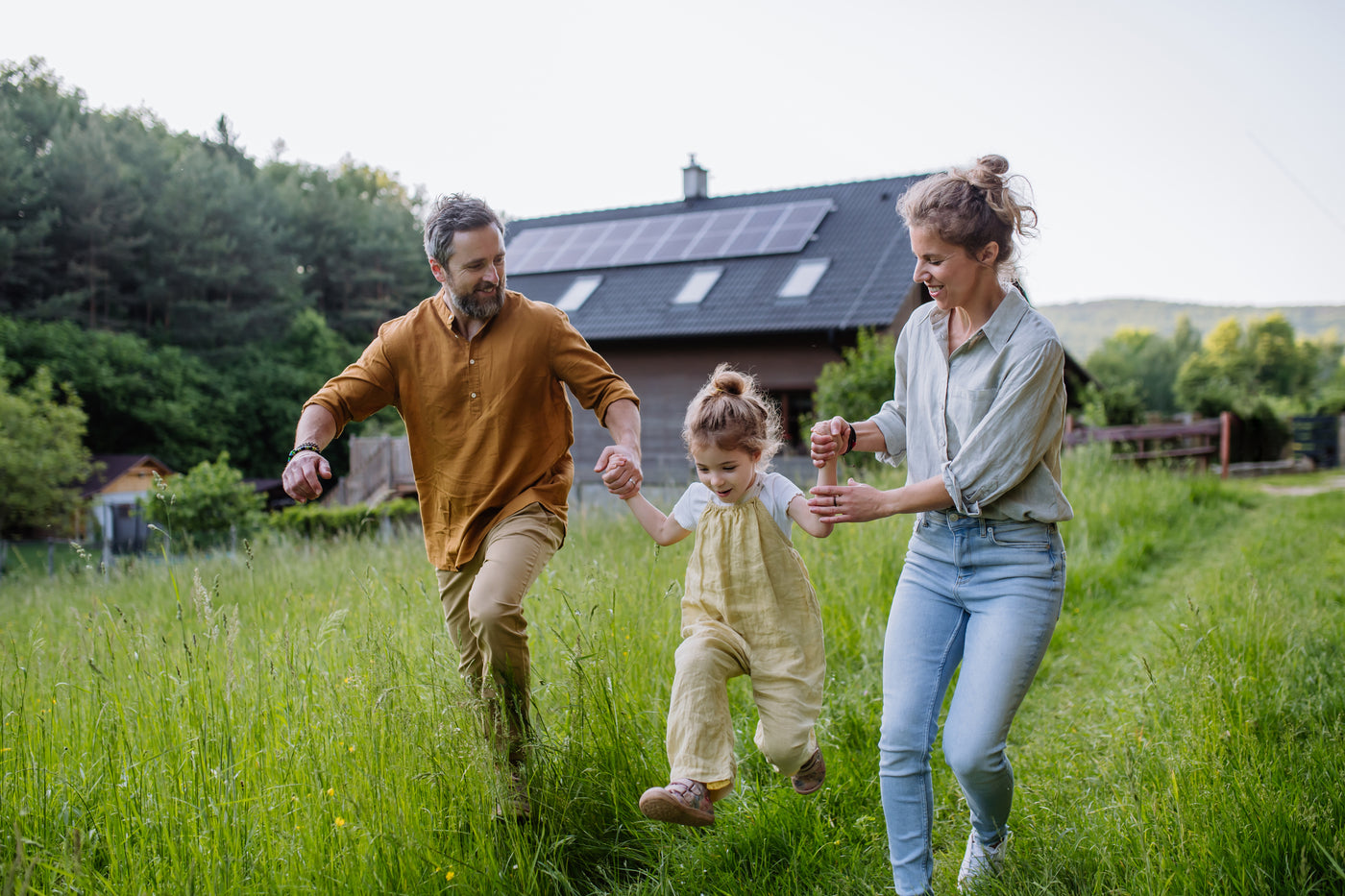 Family enjoys off-grid living in front of their solar-powered home.